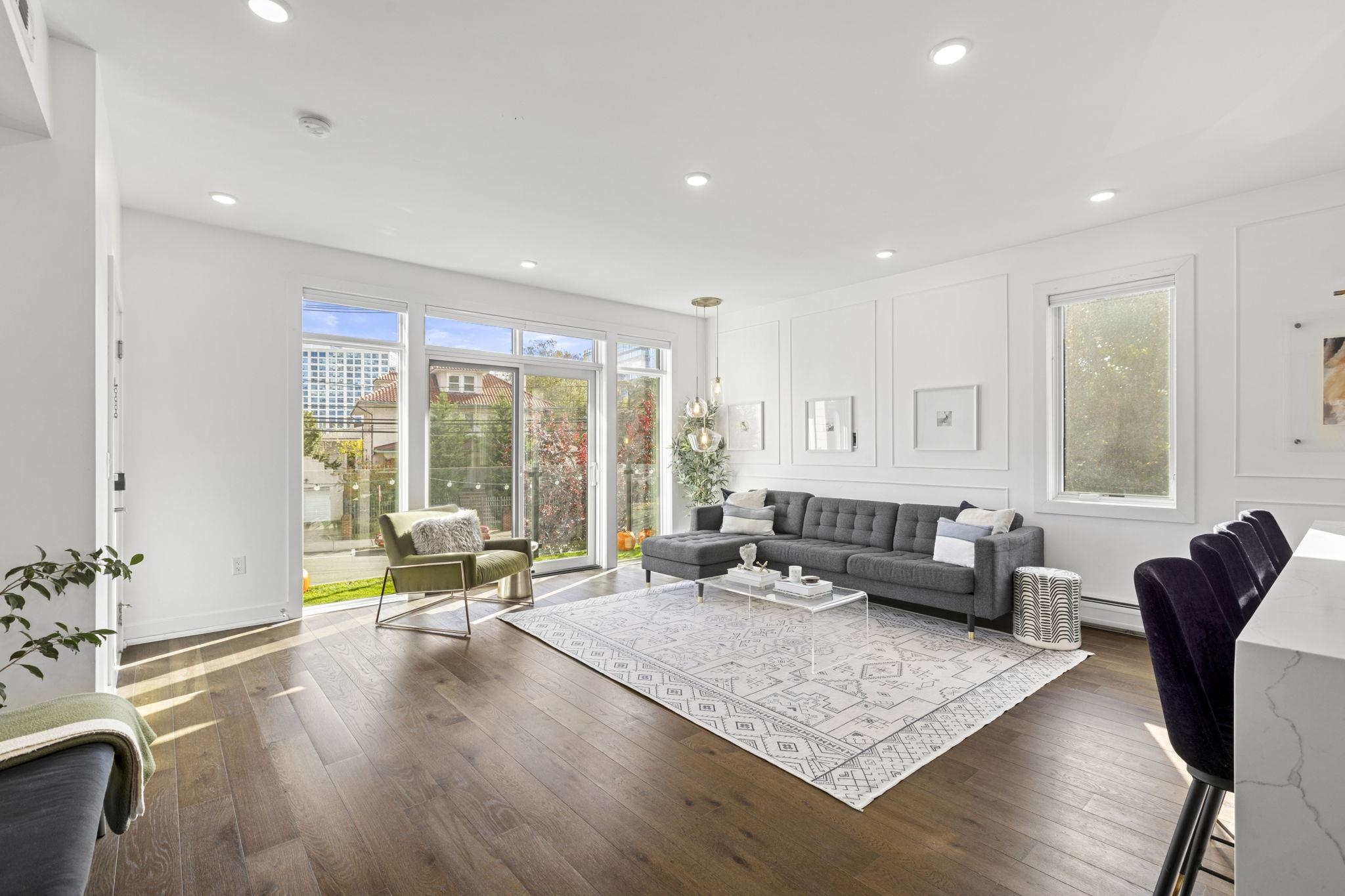 27 Hackensack Plank Road, Unit 1 Weehawken, NJ 07086 - Photo 3 of 23 a living room with furniture large windows and wooden floor