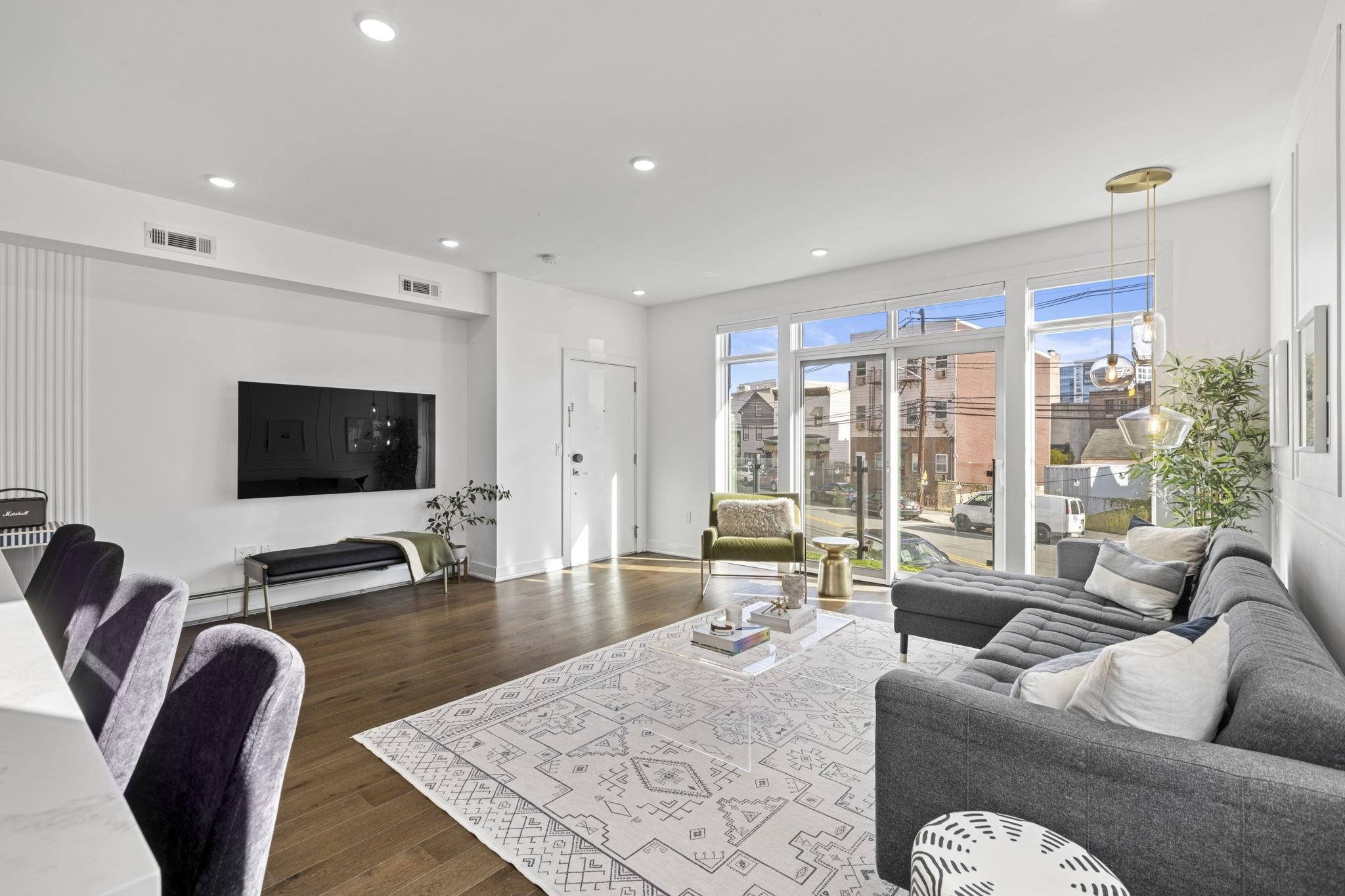 27 Hackensack Plank Road, Unit 1 Weehawken, NJ 07086 - Photo 4 of 23 a living room with furniture and a flat screen tv