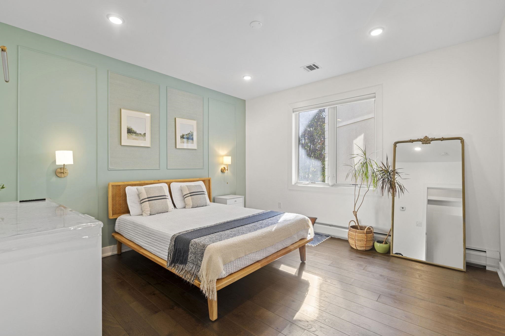 27 Hackensack Plank Road, Unit 1 Weehawken, NJ 07086 - Photo 7 of 23 a bedroom with a bed a table and a mirror