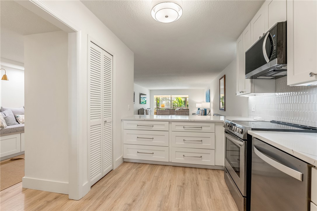 5101 Florida A1A, Unit 108 Vero Beach, FL 32963 - Photo 20 of 31 a kitchen with stainless steel appliances granite countertop a stove a sink and a refrigerator