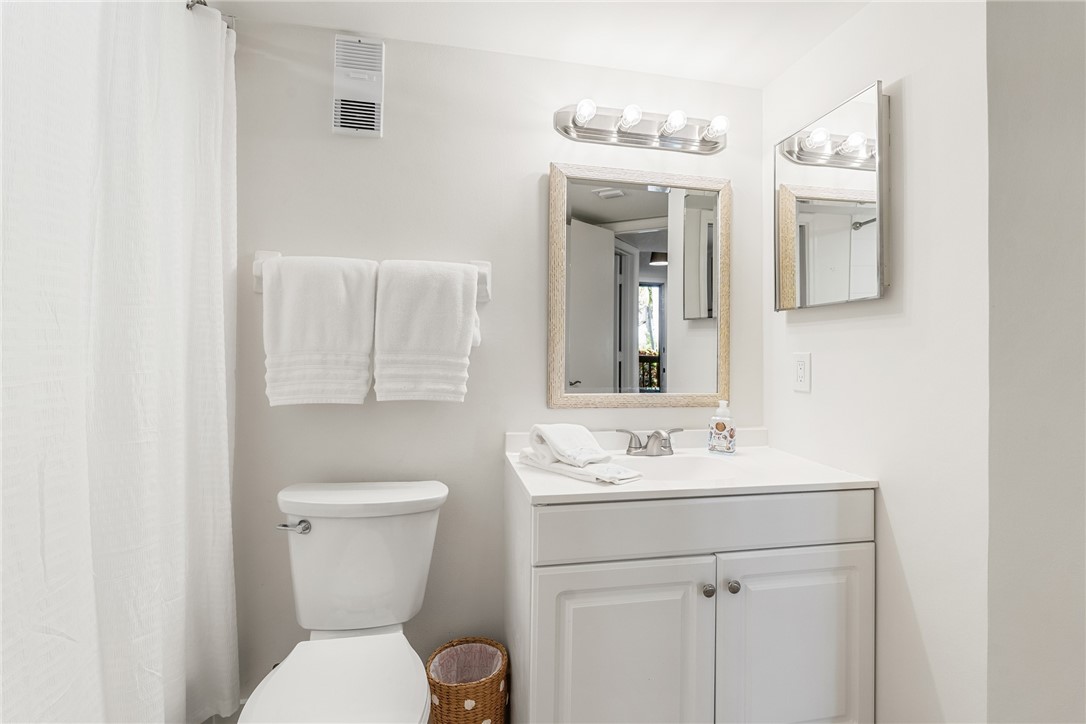 5101 Florida A1A, Unit 108 Vero Beach, FL 32963 - Photo 21 of 31 a bathroom with a toilet sink and mirror