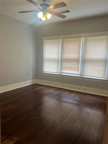 a view of a livingroom with wooden floor and a ceiling fan
