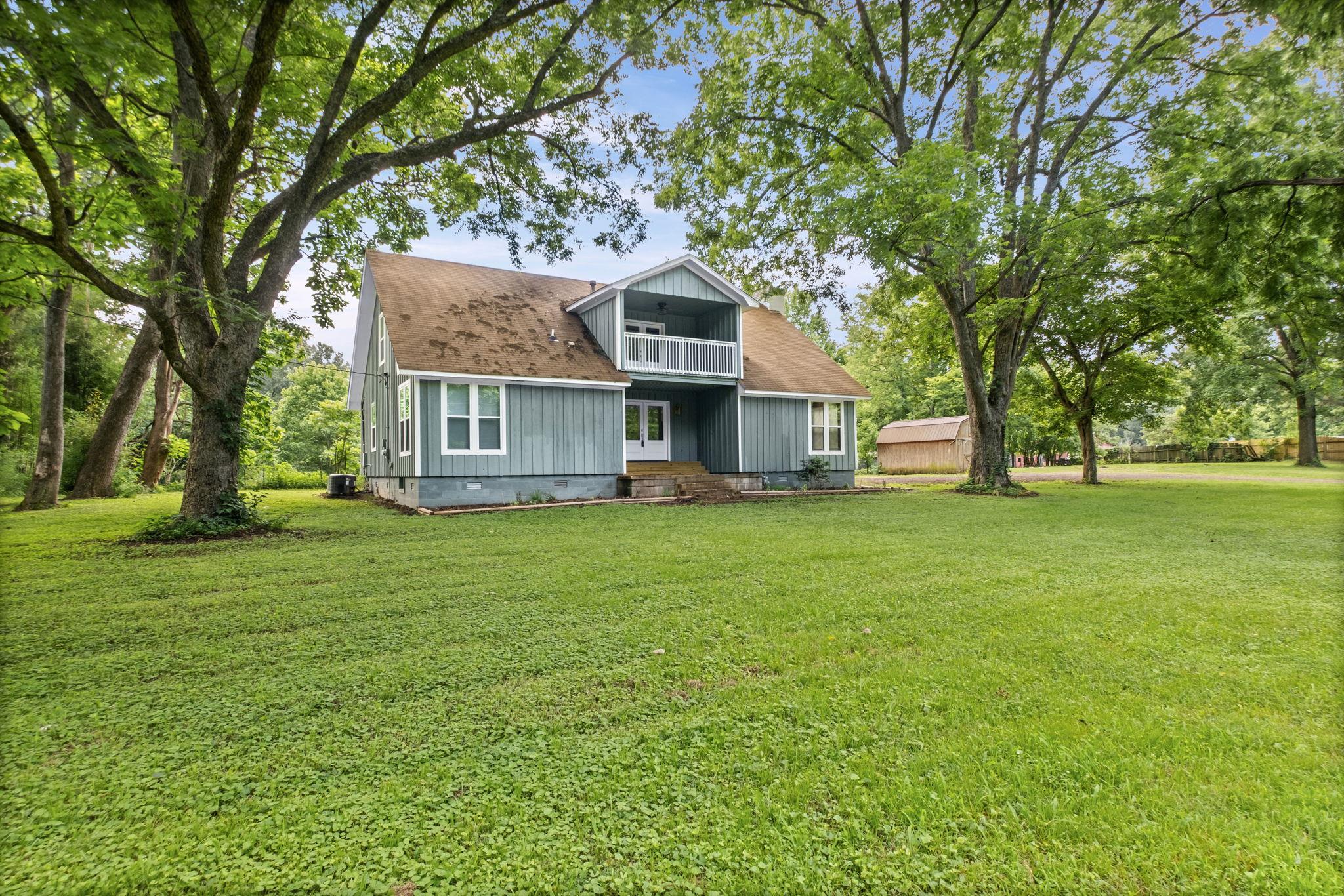 6224 Benjestown Road Memphis, TN 38127 - Photo 3 of 39 Two-story residence with light blue siding, a brown roof, and multiple windows