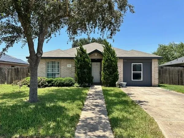 a front view of a house with a garden and trees
