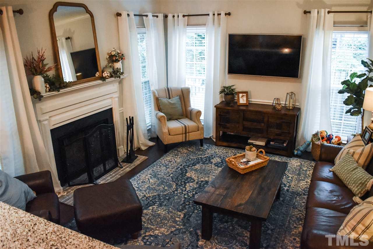 3417 Tunas Street Raleigh, NC 27616 - Photo 14 of 30 a living room with furniture a flat screen tv and a fireplace