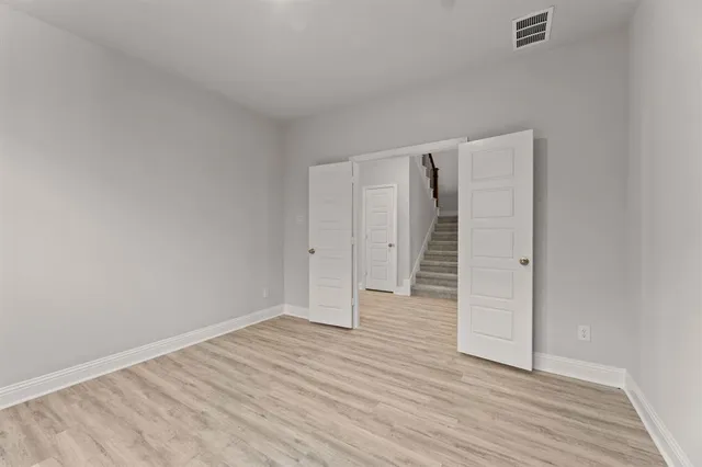 a view of empty room with wooden floor