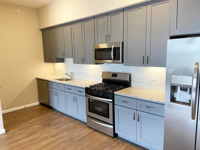 a kitchen with granite countertop wooden cabinets and stainless steel appliances