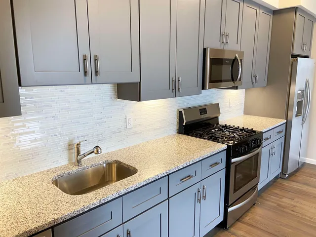 a kitchen with stainless steel appliances granite countertop a sink stove and microwave