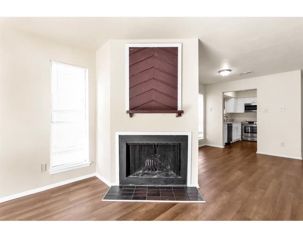 2012 West Loop Austin, TX 78758 - Photo 2 of 16 a living room with a fireplace and a wooden floor