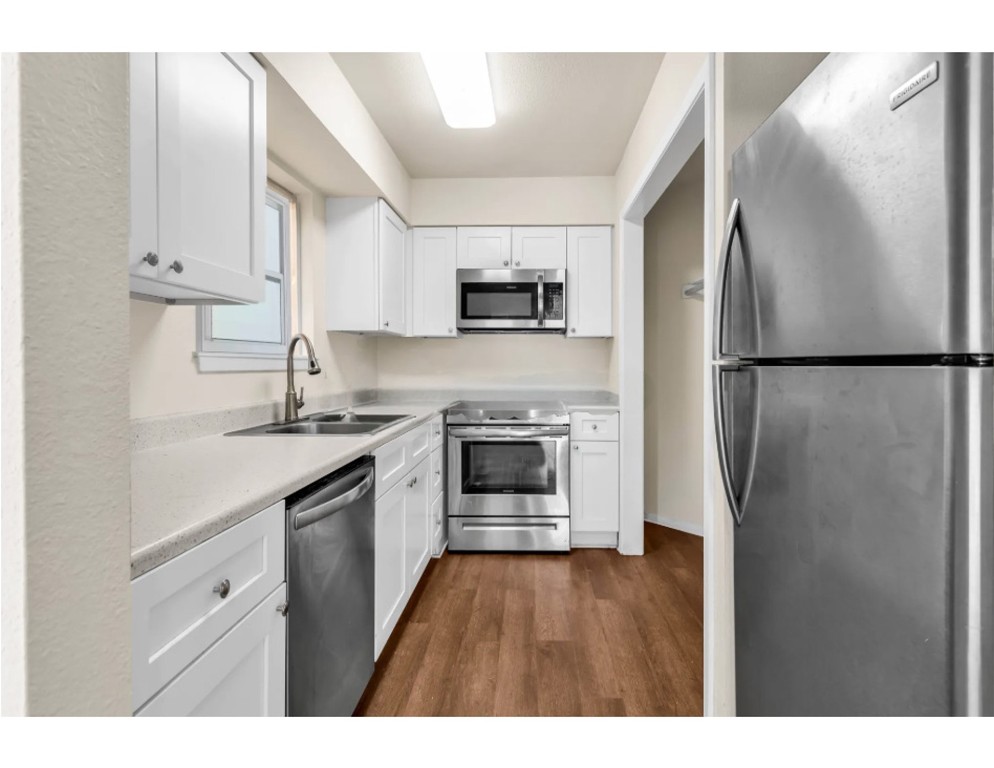 2012 West Loop Austin, TX 78758 - Photo 5 of 16 a kitchen with a refrigerator sink and cabinets