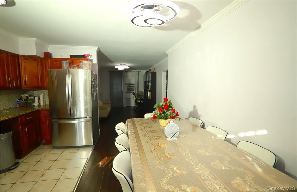 71-38 147th Street, Unit 27A Queens, NY 11367 - Photo 3 of 8 Dining area featuring crown molding and light tile patterned floors