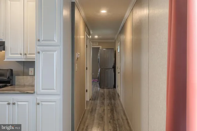a view of a hallway with wooden floor and closet
