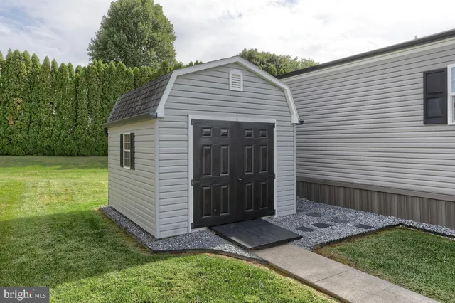 a view of a house with a yard and a large tree