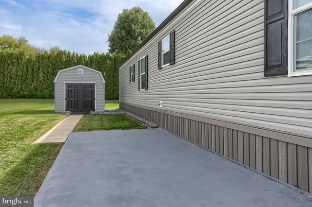 a backyard of a house with potted plants and a bench