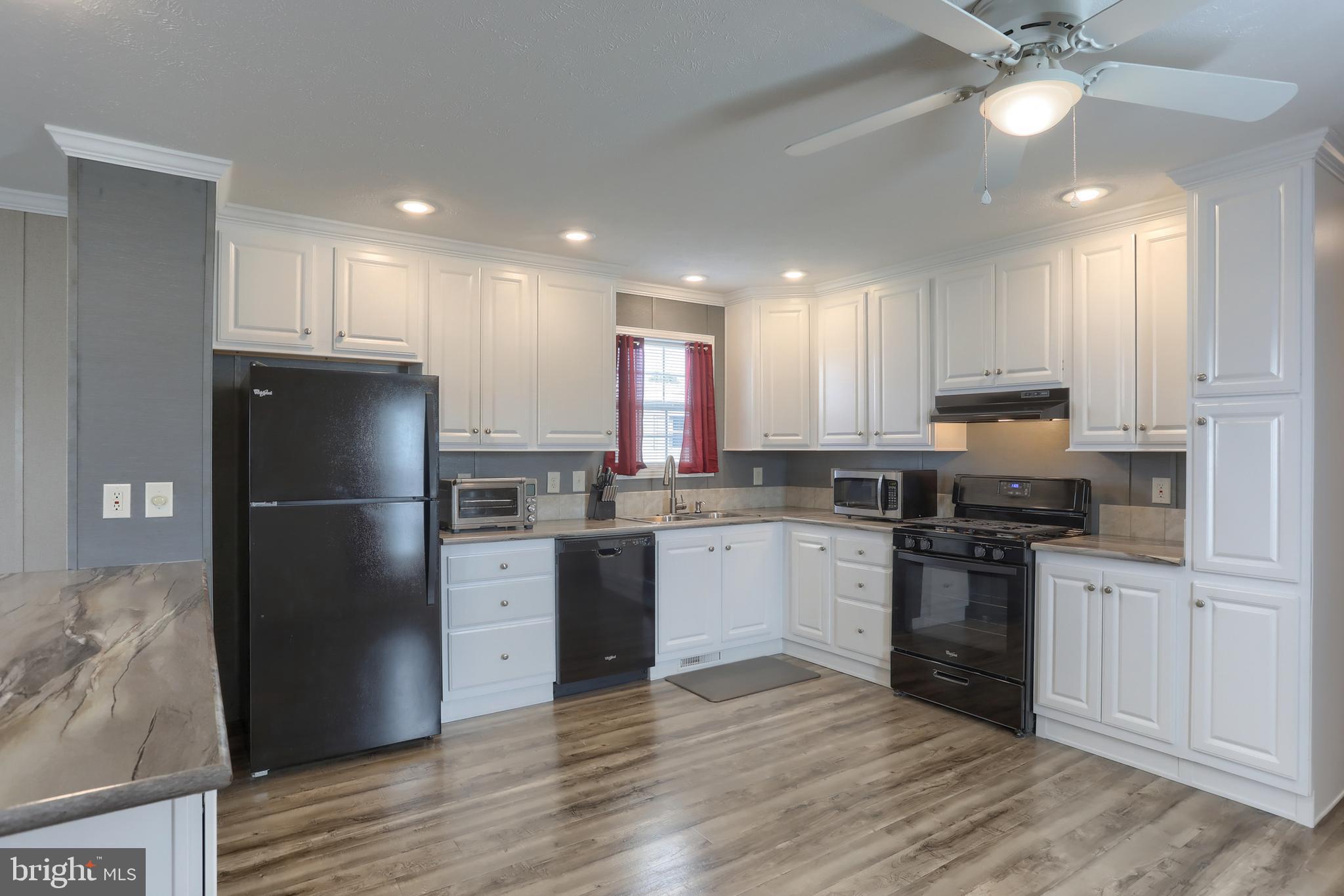1300 East Kercher Avenue, Unit 32 Myerstown, PA 17067 - Photo 8 of 27 a kitchen with a refrigerator a sink and dishwasher a stove top oven with wooden floor