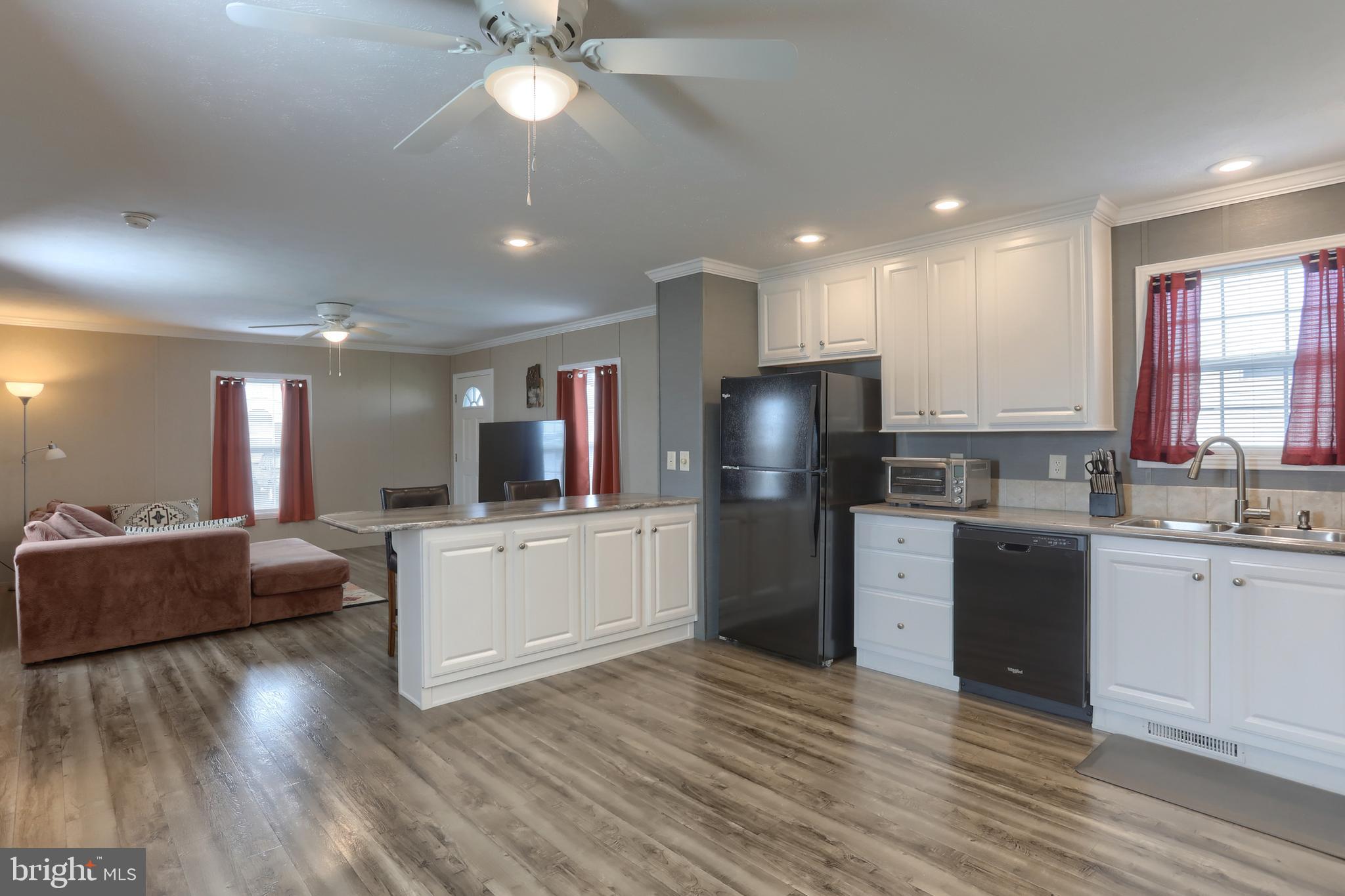 1300 East Kercher Avenue, Unit 32 Myerstown, PA 17067 - Photo 10 of 27 a large kitchen with kitchen island a refrigerator a stove a sink dishwasher a dining table and chairs with wooden floor