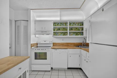 a kitchen with white cabinets and window