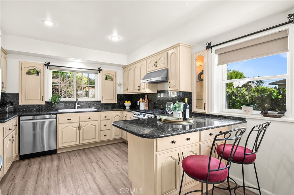 5487 Cadbury Road Whittier, CA 90601 - Photo 14 of 73 a kitchen with stainless steel appliances granite countertop a stove a sink dishwasher and a refrigerator with wooden floor