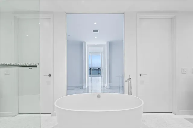 a large bedroom with a large window and walk in closet