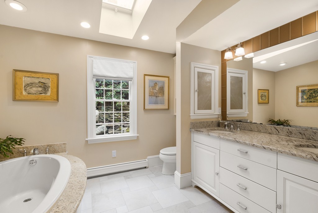 32 Cunningham Road Wellesley, MA 02481 - Photo 17 of 30 a spacious bathroom with double vanity a mirror a bathtub and a sink