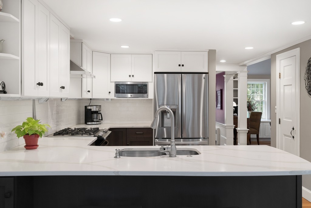 32 Cunningham Road Wellesley, MA 02481 - Photo 10 of 30 a kitchen with stainless steel appliances kitchen island granite countertop a refrigerator a sink dishwasher with a stove and white cabinets