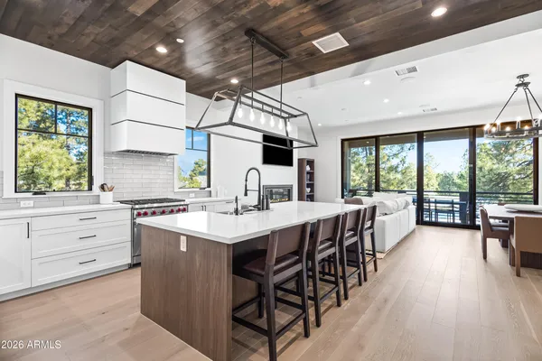 a kitchen with a table chairs stove and wooden floor