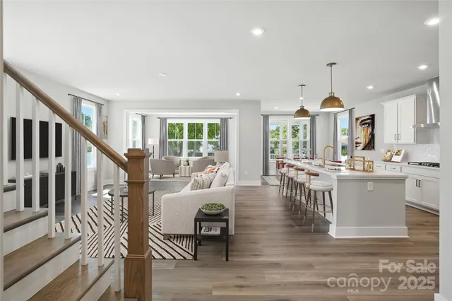 a living room with kitchen island furniture and a chandelier