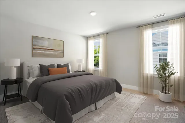 a bedroom with a large bed and a potted plant