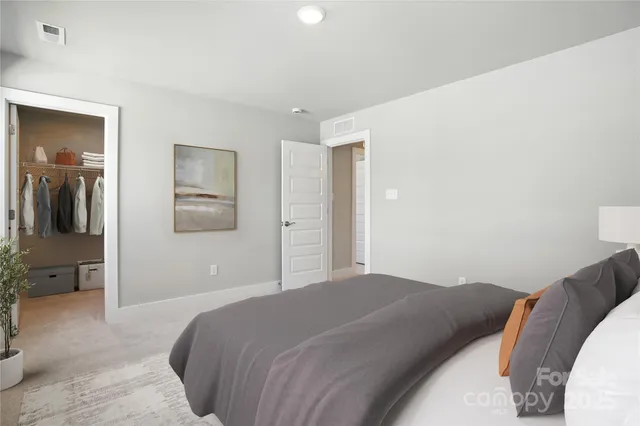 a bedroom with a large bed and chandelier