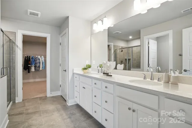 a spacious bathroom with double sink and a mirror