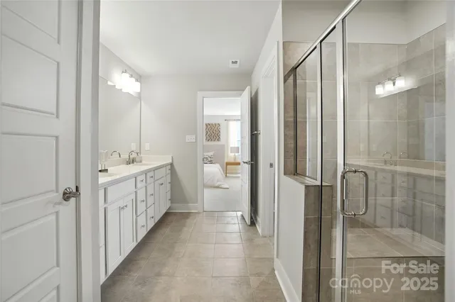 a bathroom with a double vanity sink mirror and shower