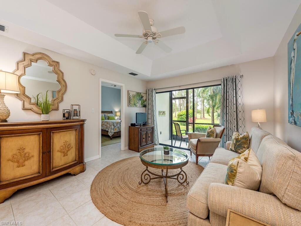 809 Augusta Boulevard, Unit 8092 Naples, FL 34113 - Photo 3 of 12 a living room with furniture a chandelier and a dining table