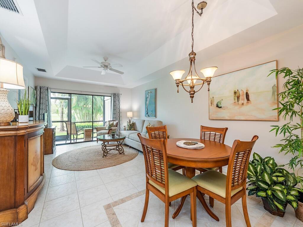 809 Augusta Boulevard, Unit 8092 Naples, FL 34113 - Photo 5 of 12 a dining room with furniture a chandelier and wooden floor
