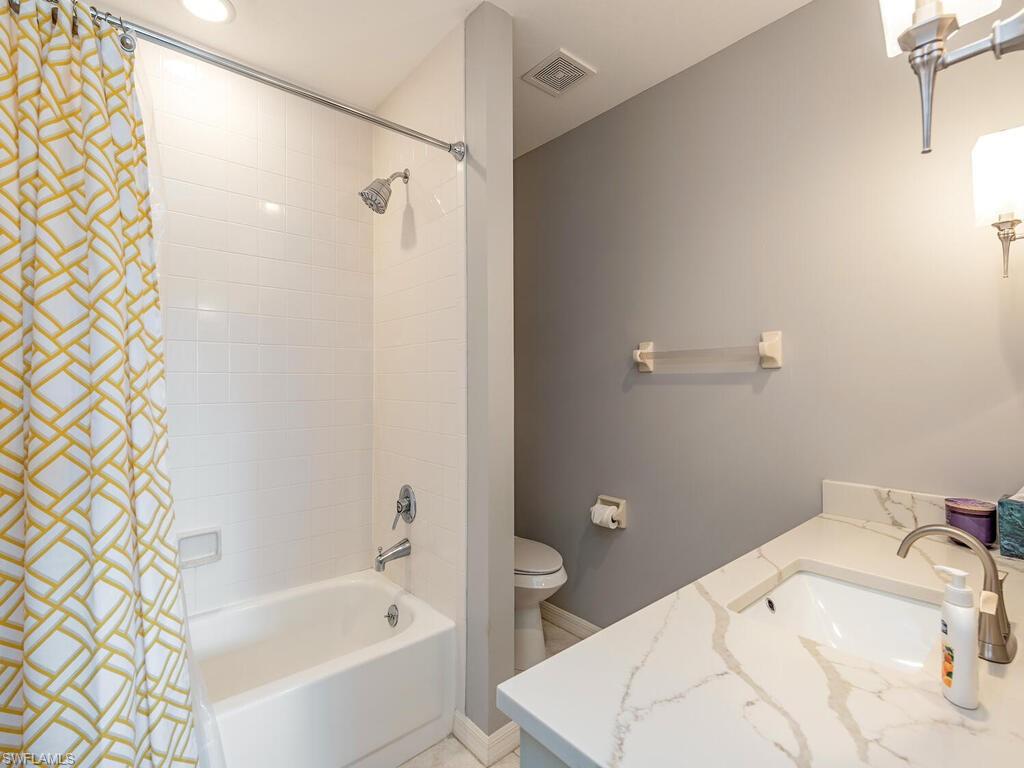 809 Augusta Boulevard, Unit 8092 Naples, FL 34113 - Photo 9 of 12 a bathroom with a sink and bathtub with toilet