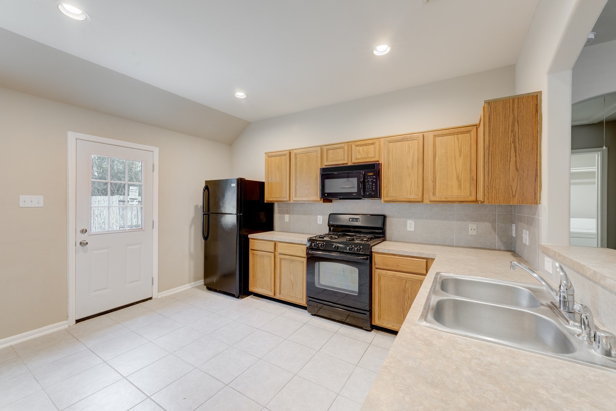 6839 Tammany Manor Lane Spring, TX 77379 - Photo 9 of 25 Eat-in kitchen offers built-in microwave and access to the back patio, convenient for grilling out