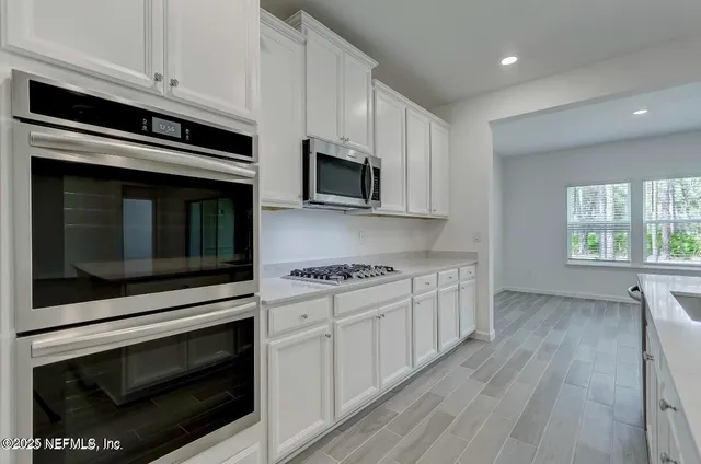 a kitchen with stainless steel appliances a stove microwave and cabinets