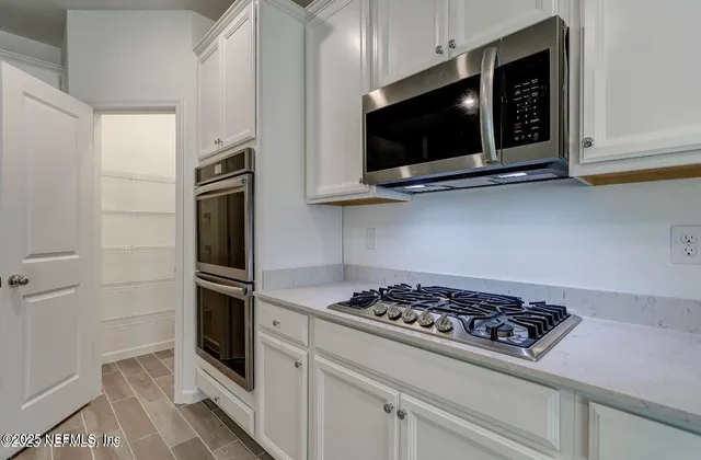 a kitchen with stainless steel appliances white cabinets and stove