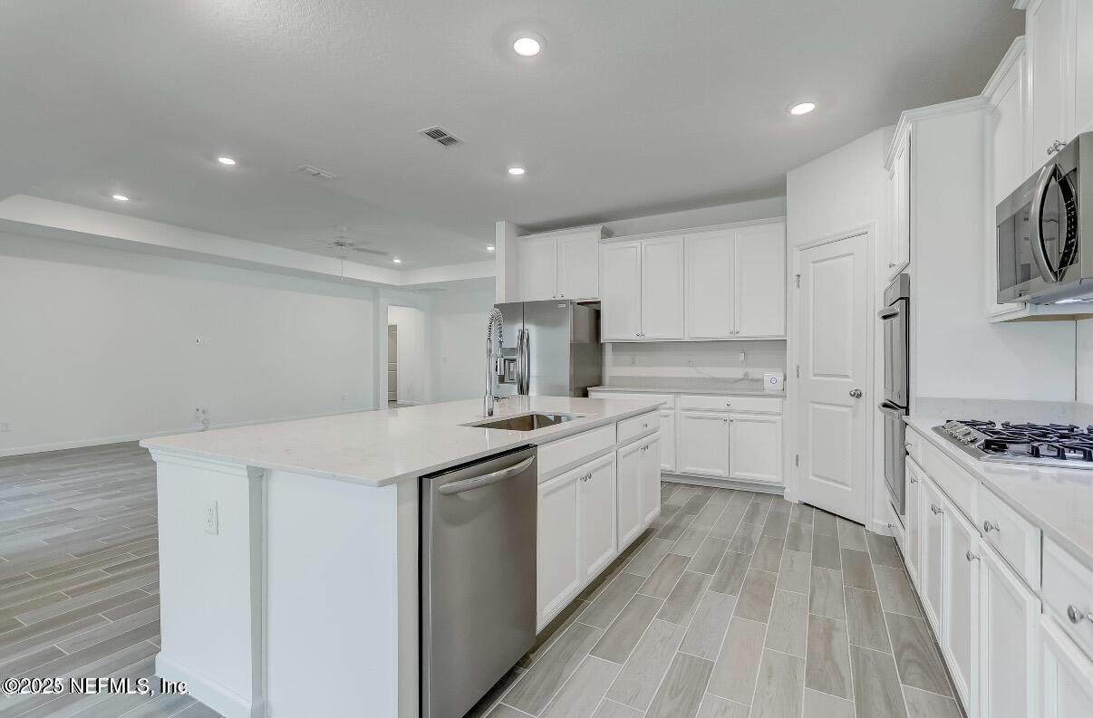 300 Gan Way St. Johns, FL 32259 - Photo 16 of 36 a kitchen with white cabinets appliances and sink