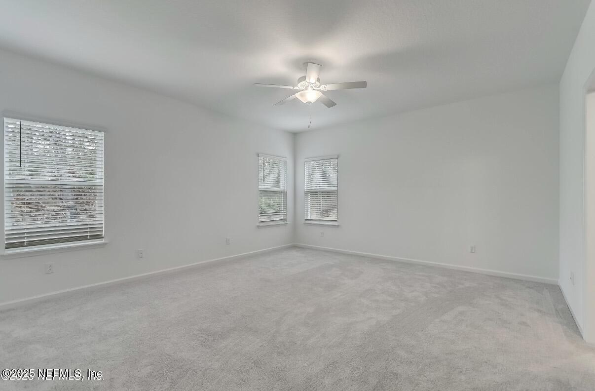 300 Gan Way St. Johns, FL 32259 - Photo 21 of 36 an empty room with chandelier fan and windows
