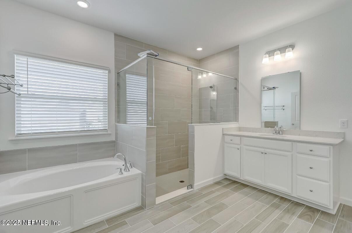 300 Gan Way St. Johns, FL 32259 - Photo 25 of 36 a bathroom with a tub sink shower and two mirror