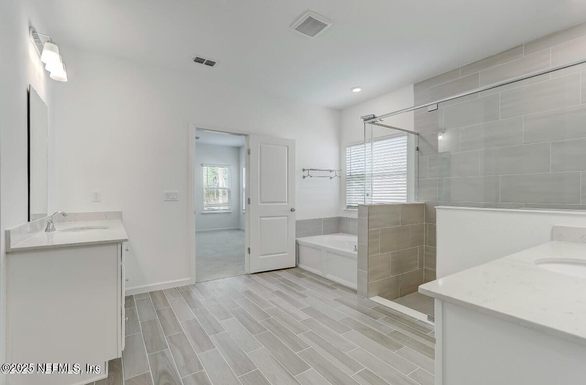 300 Gan Way St. Johns, FL 32259 - Photo 27 of 36 a large bathroom with a glass door shower a sink and a mirror