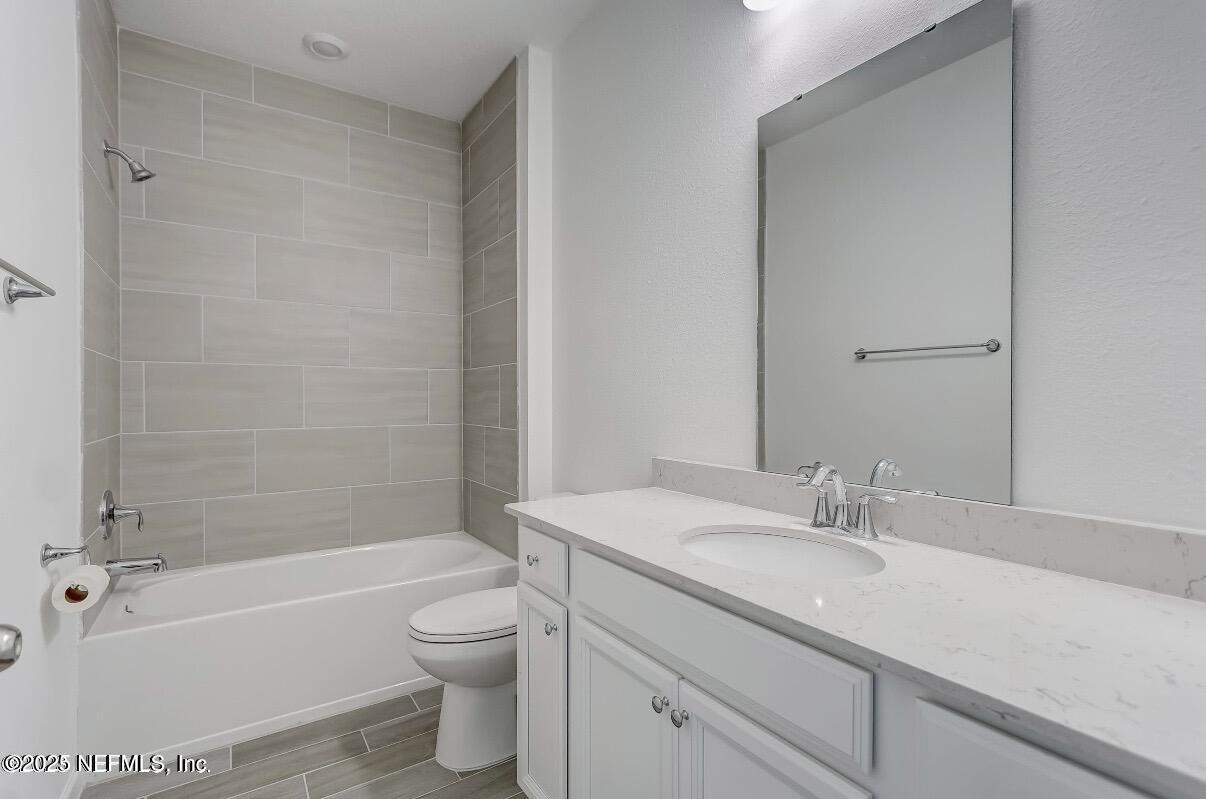 300 Gan Way St. Johns, FL 32259 - Photo 29 of 36 a bathroom with a granite countertop sink a toilet and a bathtub