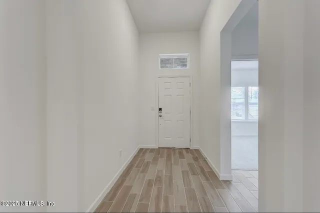 a view of a room with wooden floor and a window