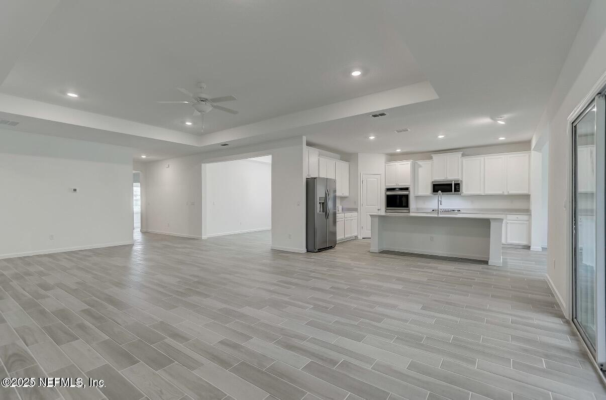 300 Gan Way St. Johns, FL 32259 - Photo 9 of 36 a view of kitchen with kitchen island a sink wooden floor and a refrigerator