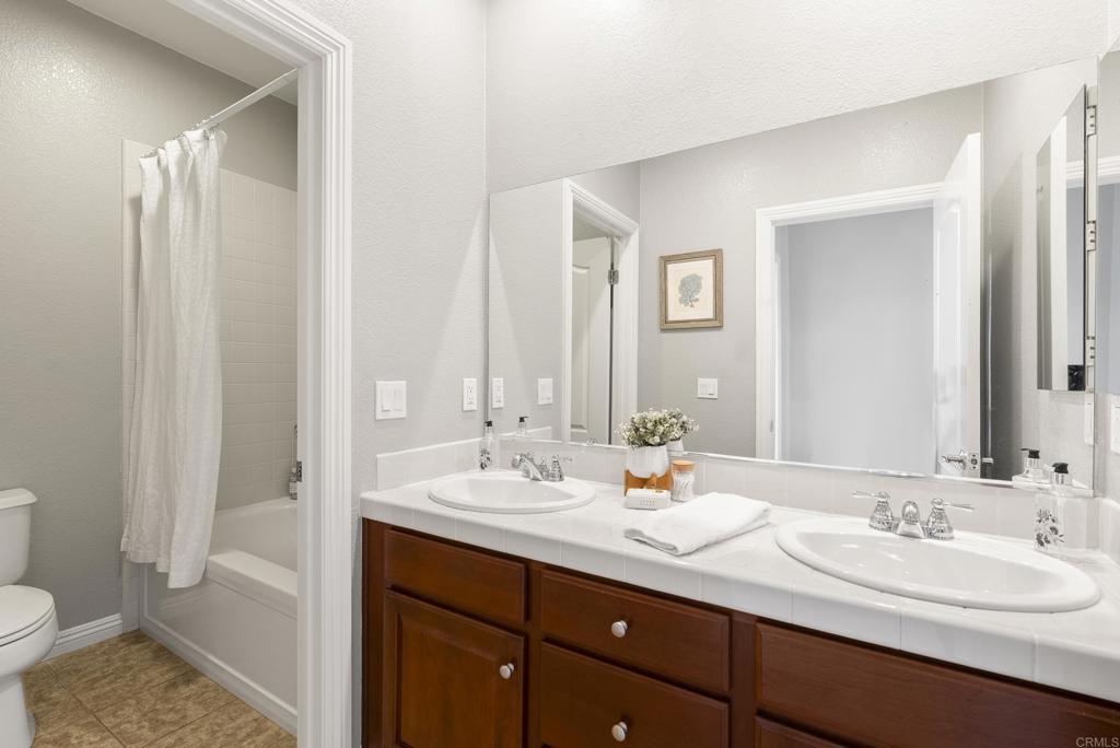 1407 Eclipse Drive San Marcos, CA 92078 - Photo 24 of 32 a bathroom with a double vanity sink and a mirror