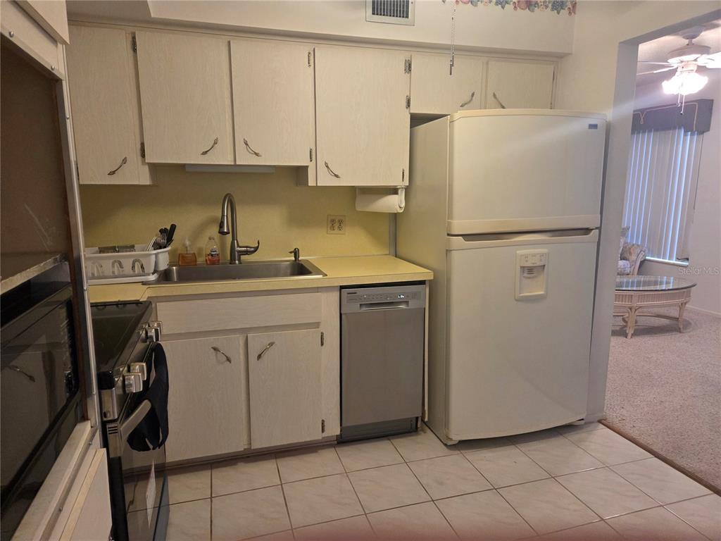2386 Sumatran Way, Unit 14 Clearwater, FL 33763 - Photo 11 of 71 a kitchen with a refrigerator sink and cabinets