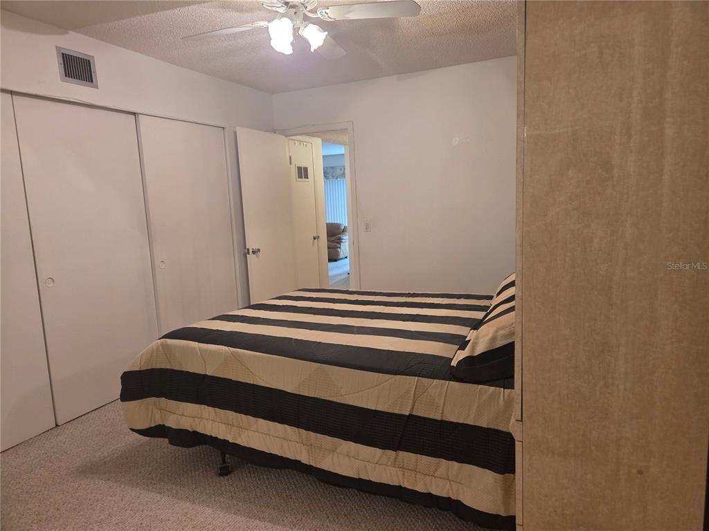 2386 Sumatran Way, Unit 14 Clearwater, FL 33763 - Photo 15 of 71 a bedroom with a bed and a chandelier