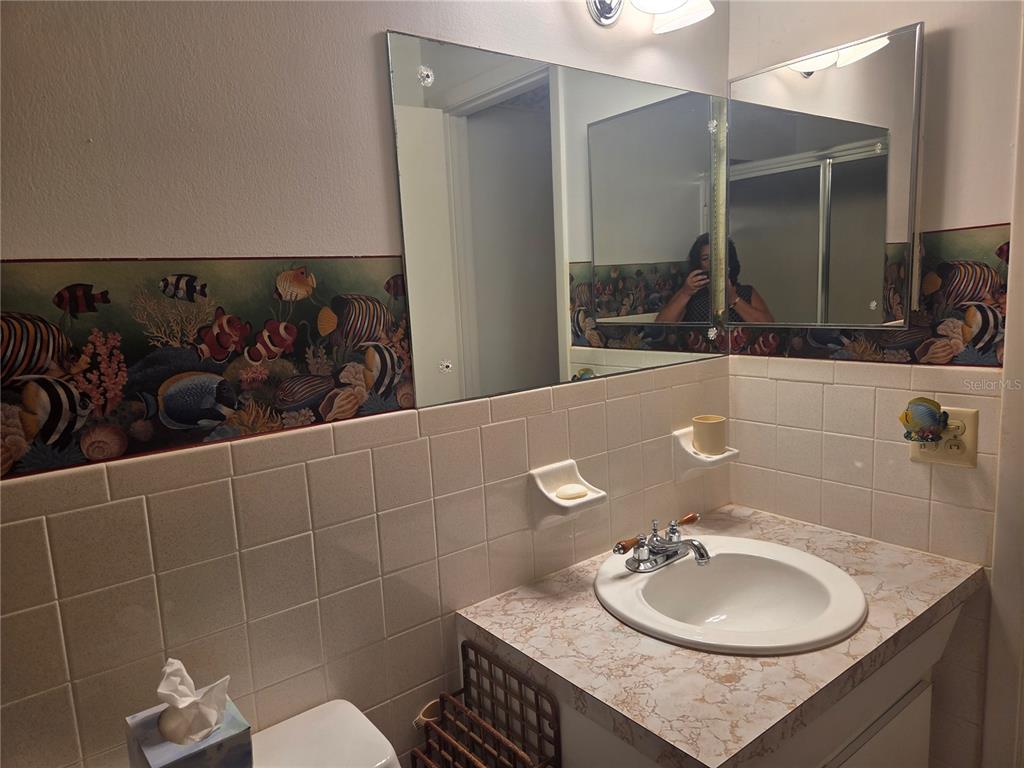 2386 Sumatran Way, Unit 14 Clearwater, FL 33763 - Photo 19 of 71 a bathroom with a granite countertop sink and a mirror