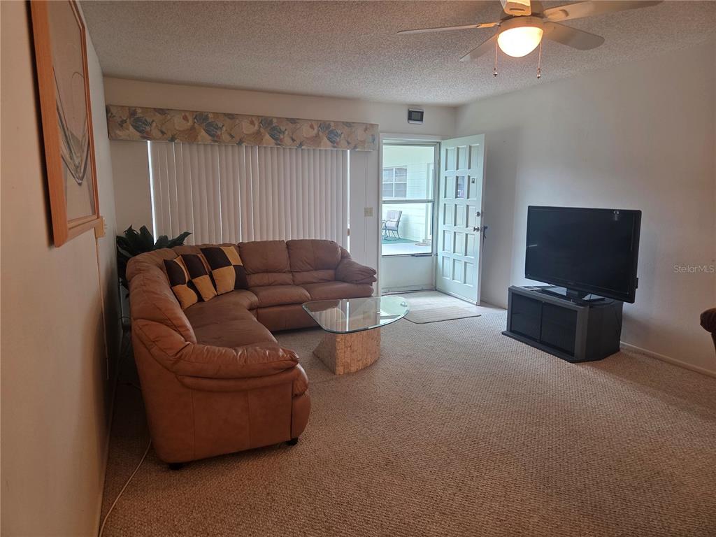 2386 Sumatran Way, Unit 14 Clearwater, FL 33763 - Photo 7 of 71 a living room with furniture a flat screen tv and a window
