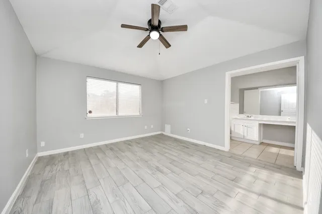 an empty room with a window and a ceiling fan